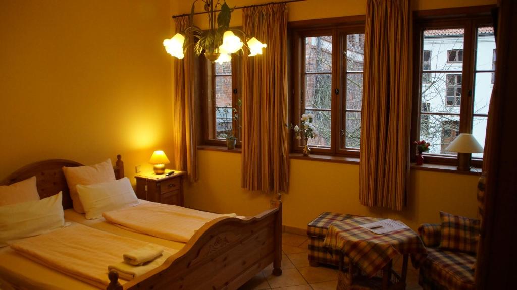 a bedroom with two beds and two windows at Gästehaus am Wasserturm in Lüneburg