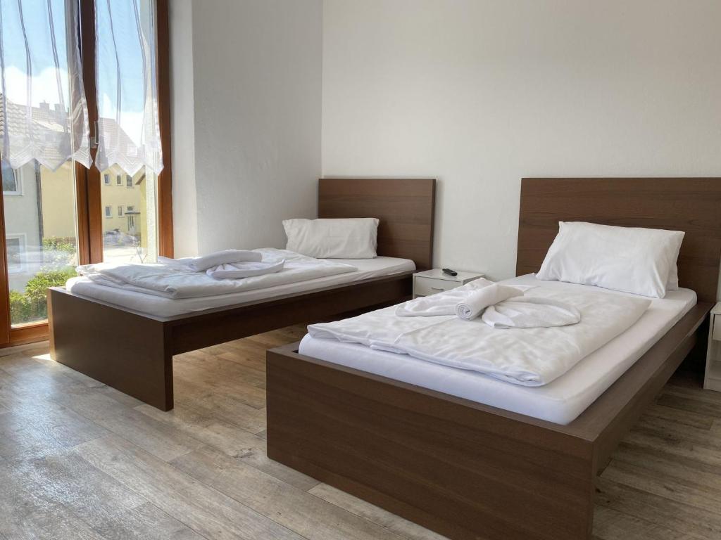 2 łóżka pojedyncze w pokoju z oknem w obiekcie SAD110 - Gemütliche Monteurwohnungen in Schwandorf w mieście Schwandorf