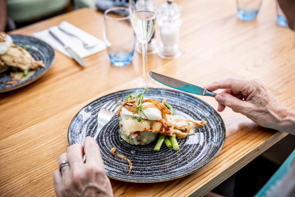 two people sitting at a table with a plate of food at The Marine in Whitstable