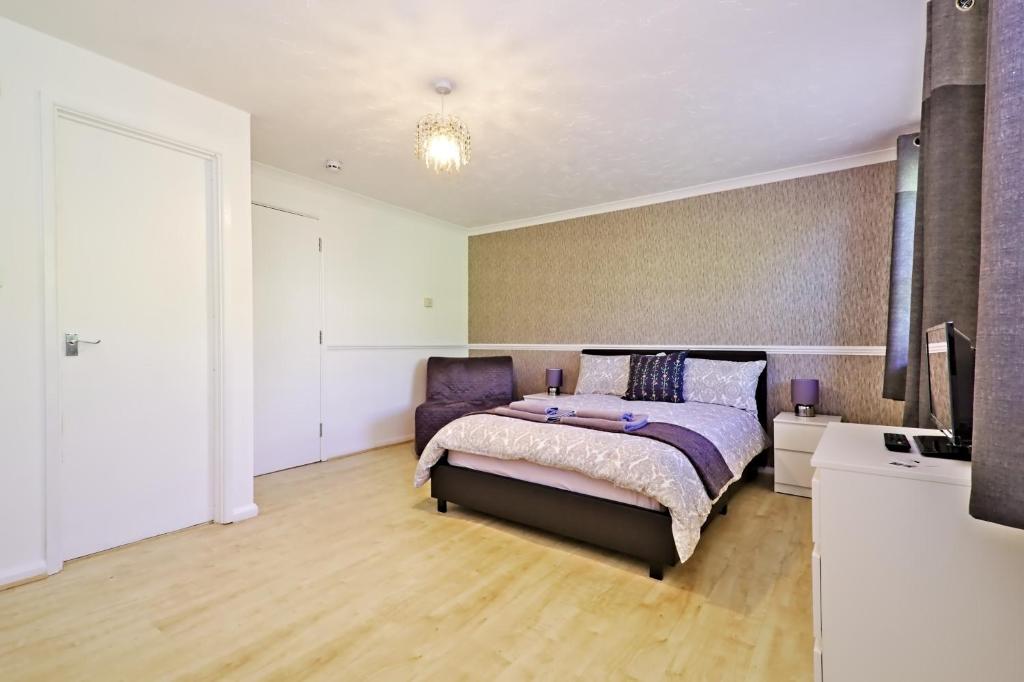 a bedroom with a bed and a tv in it at Harlinger Lodge Annexe in London