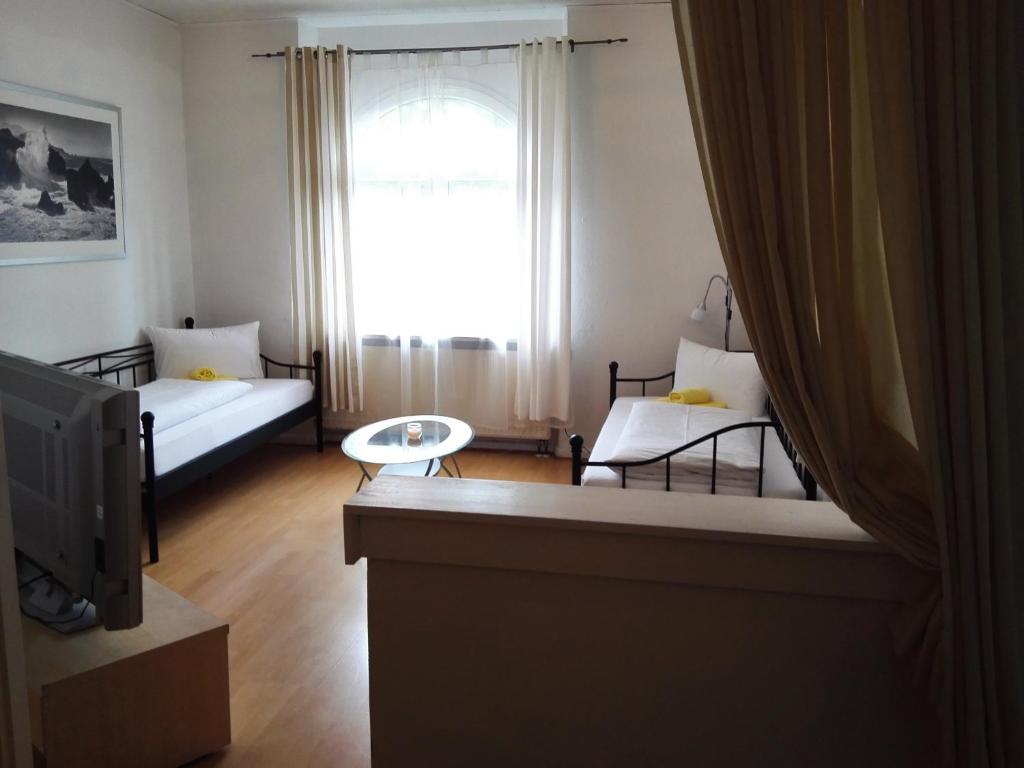 uma sala de estar com duas camas e uma televisão em Harsdörffer Apartment em Nurembergue