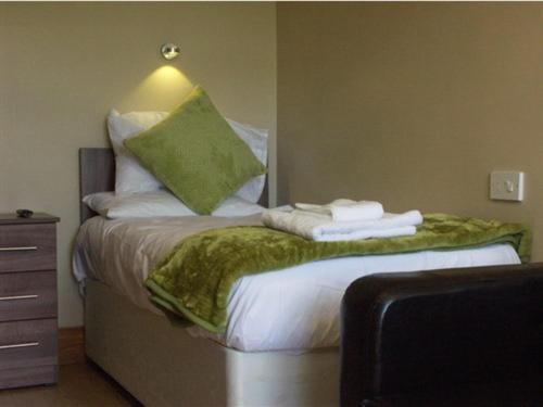 a bed with a green pillow on top of it at Budget Hayat express hotel in Durham