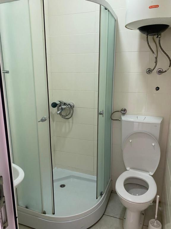 a bathroom with a toilet and a glass shower at Apartments Boss in Budva