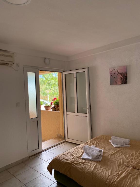 a bedroom with a bed and a sliding glass door at Apartments Boss in Budva