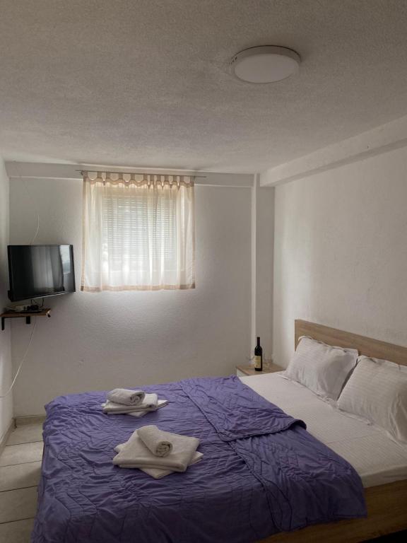 a bedroom with a bed with towels on it at Apartments Boss in Budva