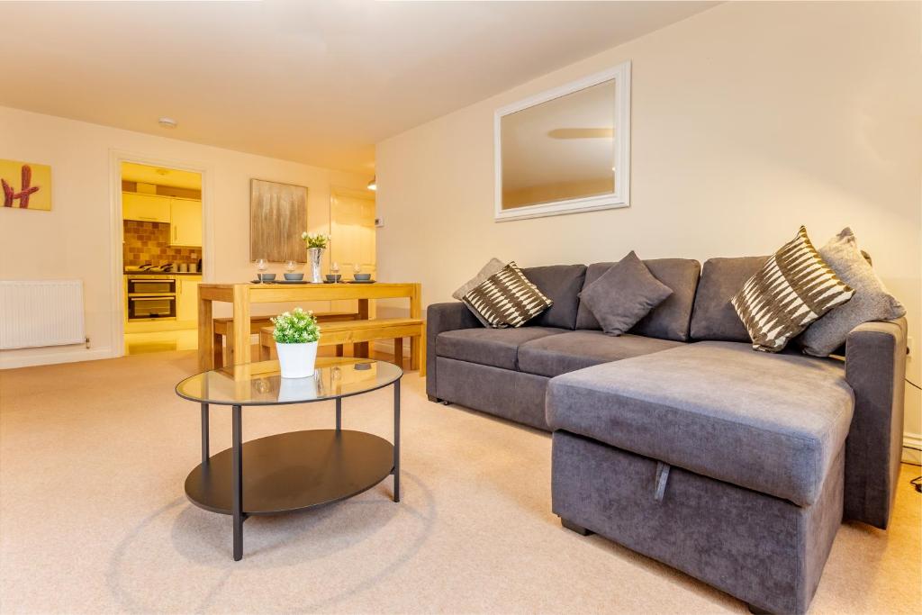 ein Wohnzimmer mit einem Sofa und einem Tisch in der Unterkunft Guest Homes - Hillbrook House Apartment in Great Malvern