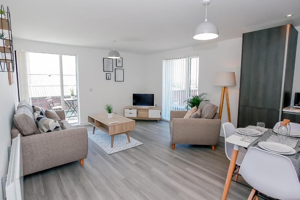 Hilltop Serviced Apartments- Northern Quarter في مانشستر: غرفة معيشة مع كنبتين وتلفزيون