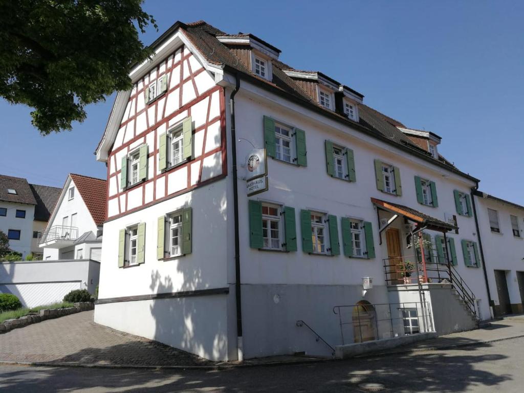 a large white building with green shuttered windows at Hotel Hohe Schule in Bad Überkingen