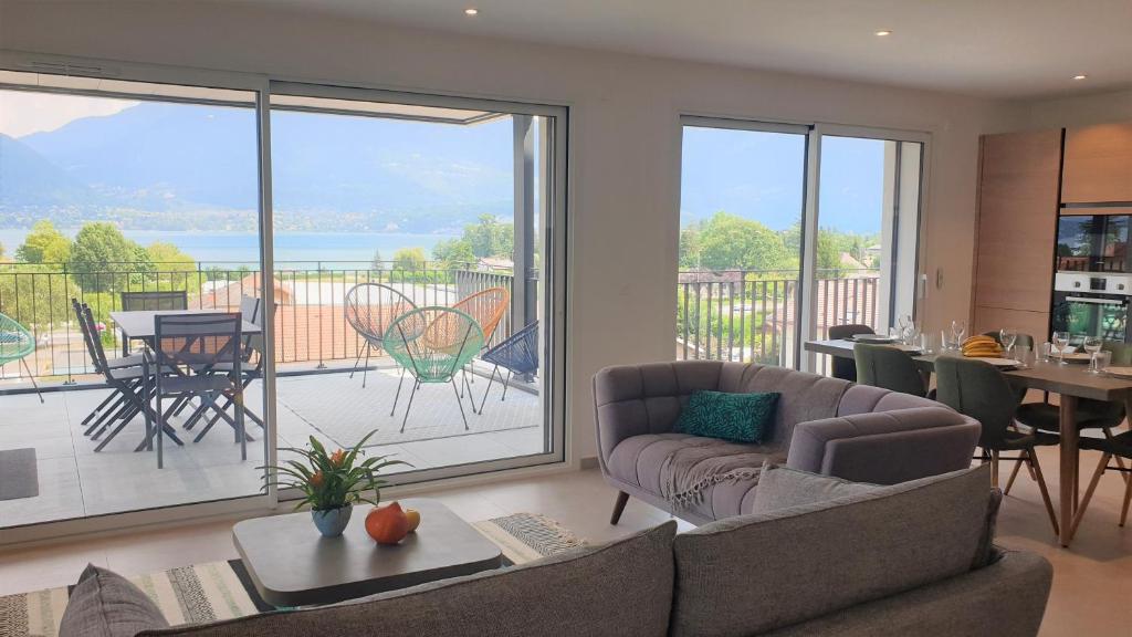 a living room with a couch and a large window at Appartement Laudon in Sévrier