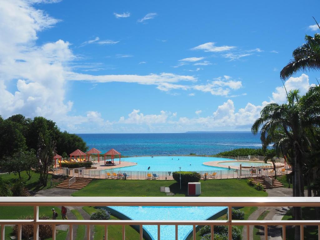 - une vue sur la piscine depuis le balcon du complexe dans l'établissement Holidays Guadeloupe -Paradise -Anse des Rochers, à Belle-Allée