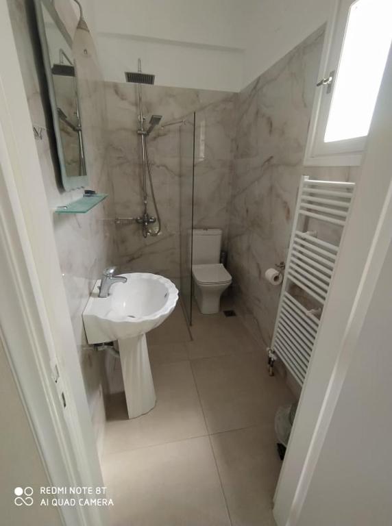 a bathroom with a sink and a toilet at Vassiliki Studios in Andros