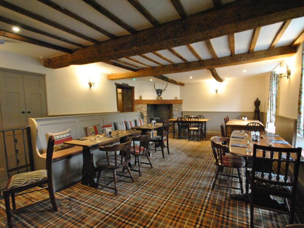 a restaurant with tables and chairs and a fireplace at The Hood Arms in Kilve