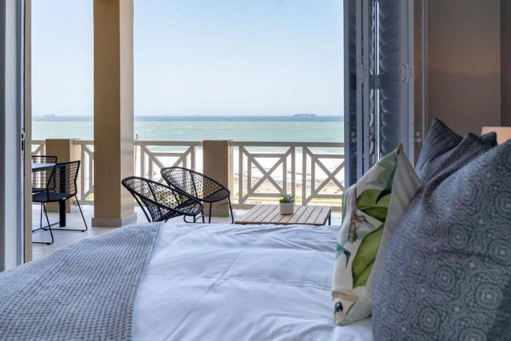 ein Schlafzimmer mit Bett und Blick auf das Meer in der Unterkunft Waterfront Getaway, 2 Bedroom Seaside Bliss in Umdloti