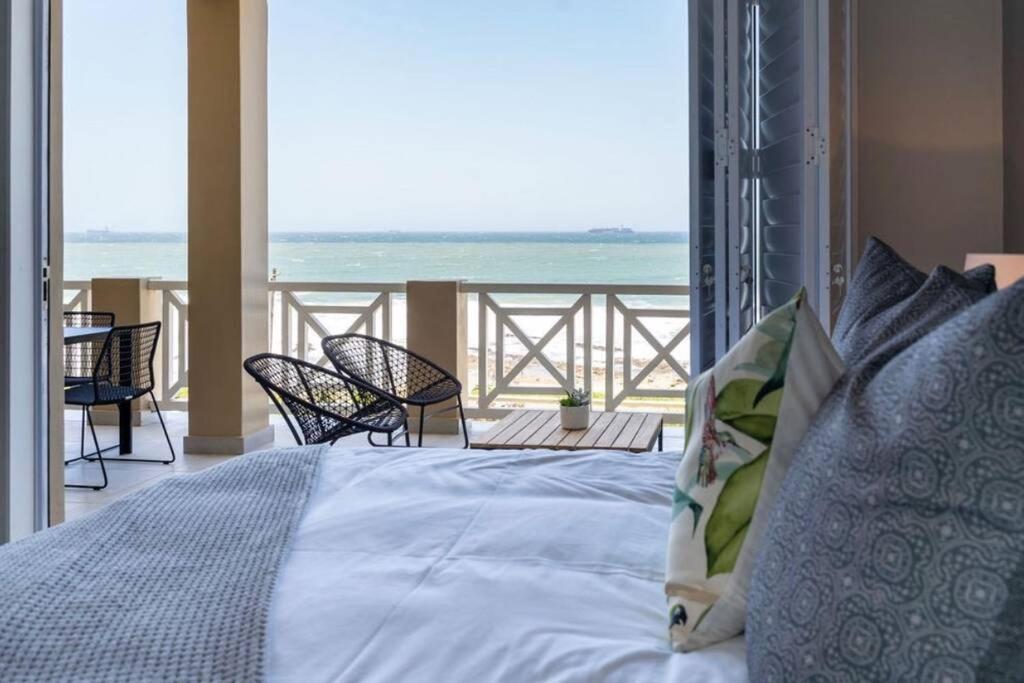 a bedroom with a bed and a view of the ocean at Waterfront Getaway, 2 Bedroom Seaside Bliss in Umdloti