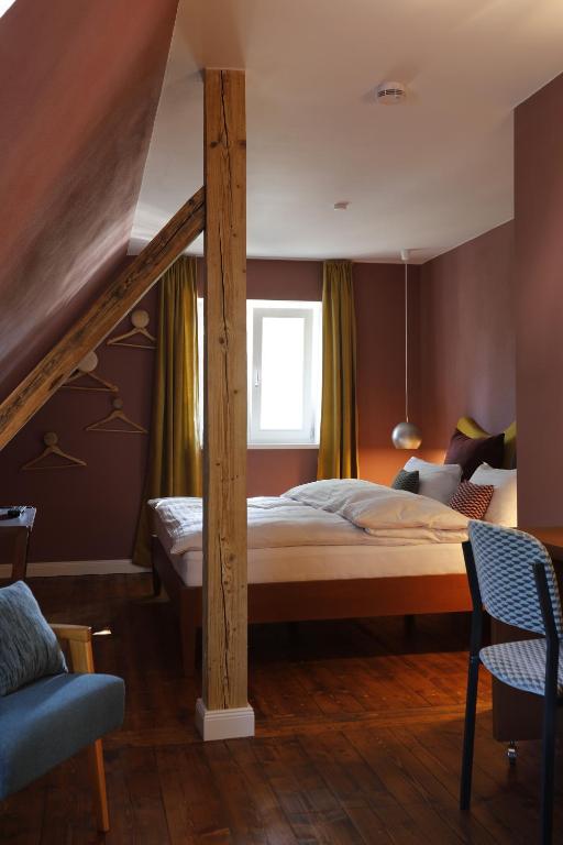 um quarto com uma cama grande e um poste de madeira em Molo Rouge em Wunsiedel