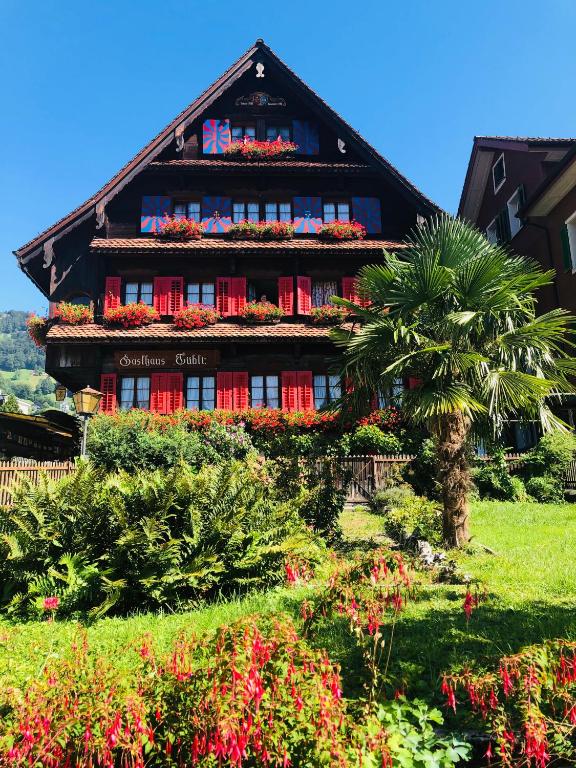 ein Gebäude mit einer Palme davor in der Unterkunft Gasthaus Tübli Gersau in Gersau