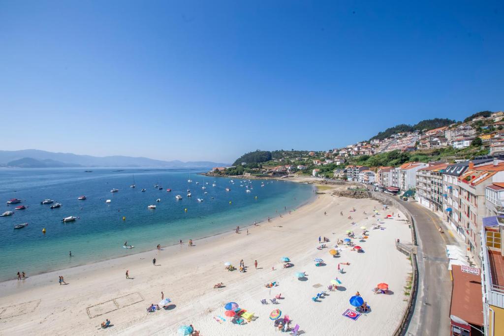 vistas a una playa con gente y al océano en Hotel Nautilus, en Raxó