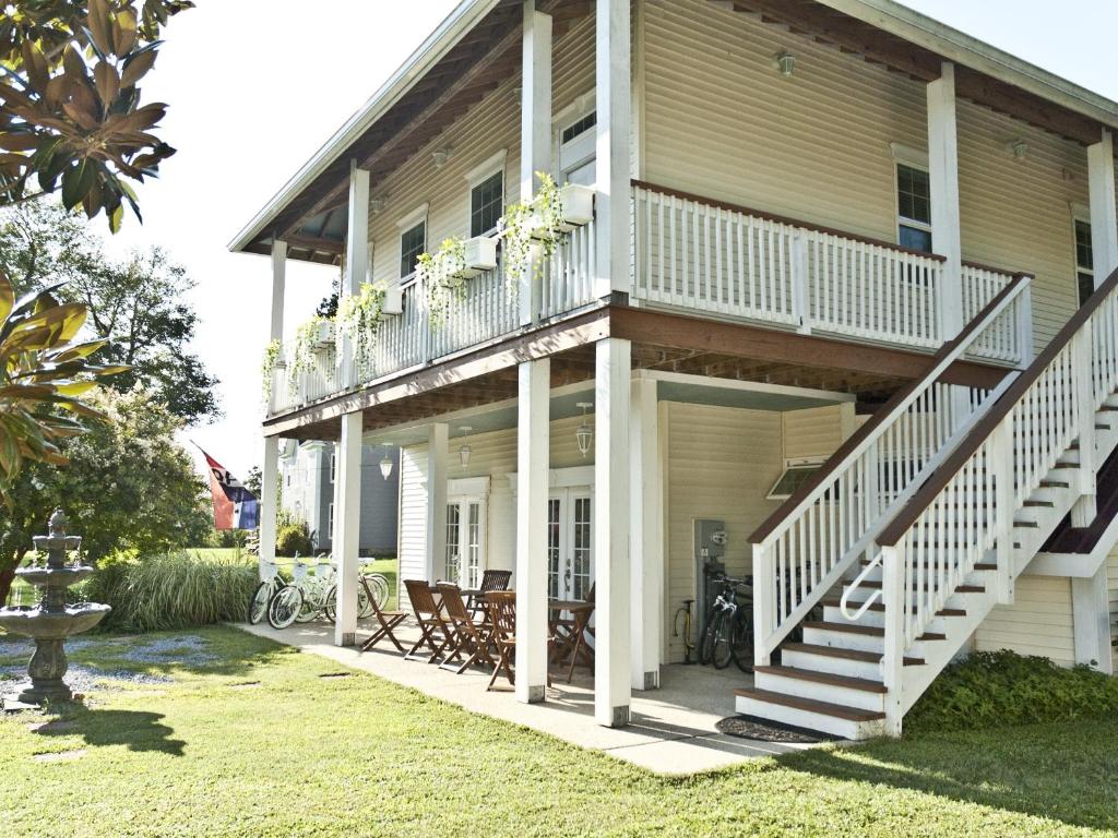 uma casa com um alpendre e uma varanda com cadeiras em Haven Point Inn em Rock Hall