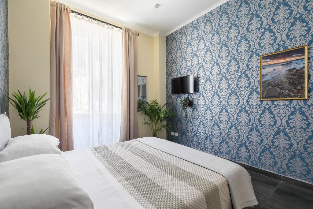 ローマにあるTevere Rome Apartmentsの青い壁のベッドルーム1室(ベッド1台付)