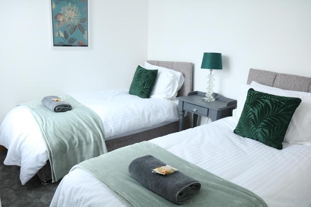 een hotelkamer met 2 bedden en handdoeken erop bij Ideal Lodgings in Bury - Whitefield in Bury