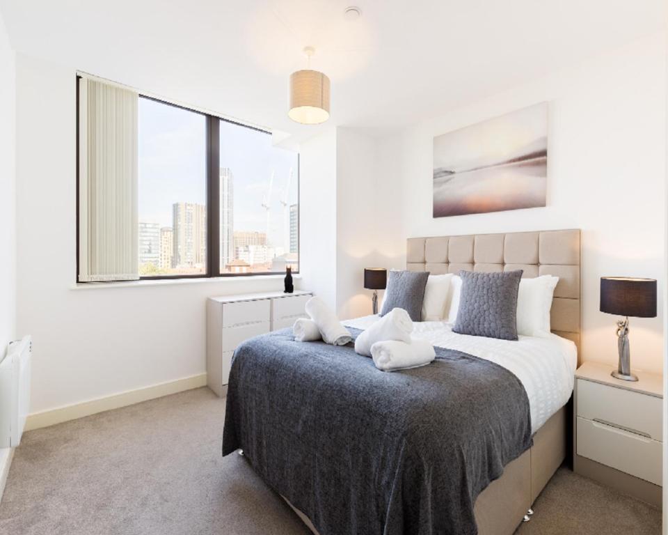 a bedroom with a large bed and a large window at KCS Luxury Apartment - Broad Street Birmingham in Birmingham