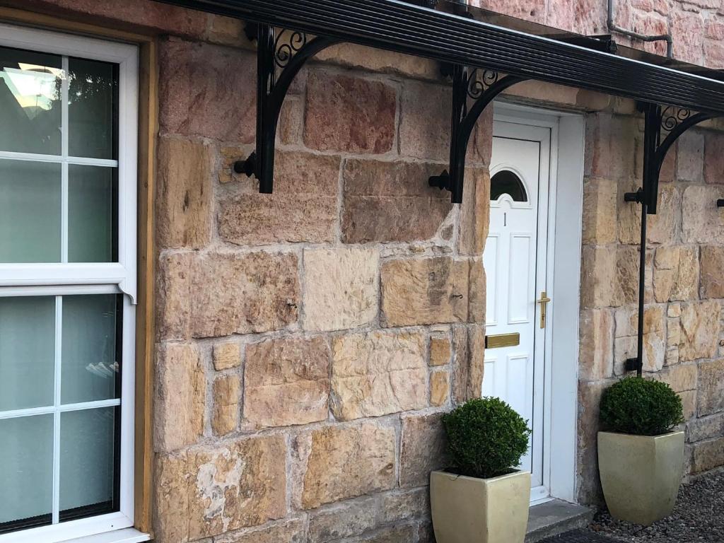 una casa de piedra con dos plantas delante de una puerta en The Clacks Rustic Abode, en Tillicoultry