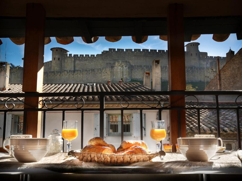 une table avec du pain et un château en arrière-plan dans l'établissement Les clés de la Cité - 5 appartements, à Carcassonne