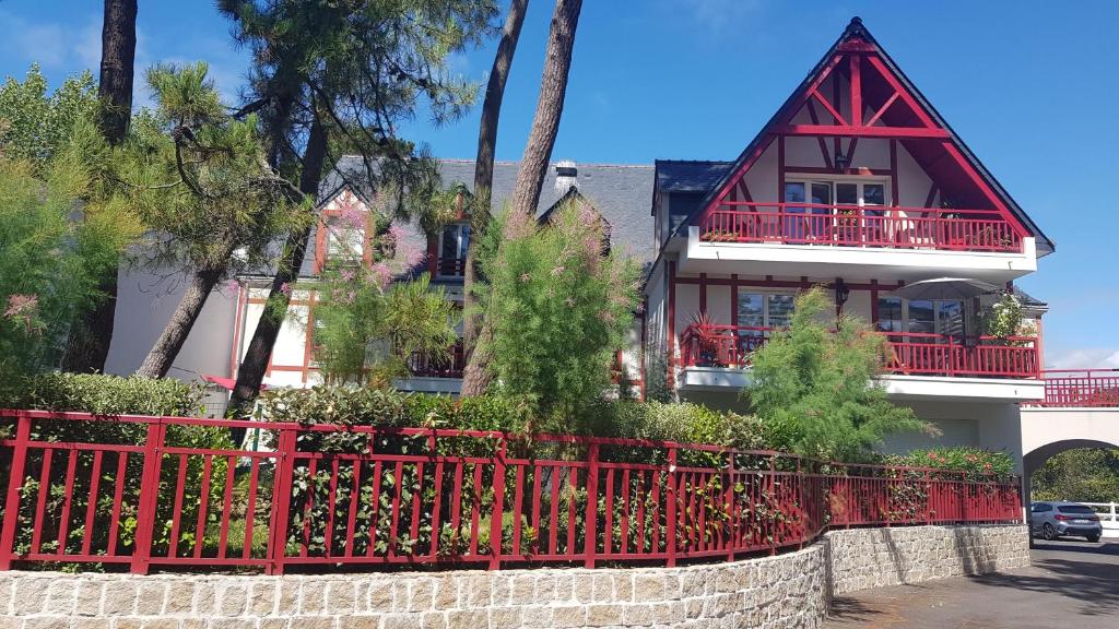 une clôture rouge devant une maison dans l'établissement La Lanterne, à La Baule