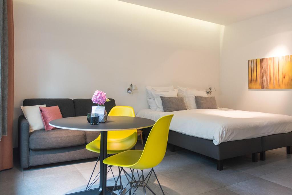 a bedroom with a bed and a table and a couch at Marcel de Gand Business & Travel in Ghent