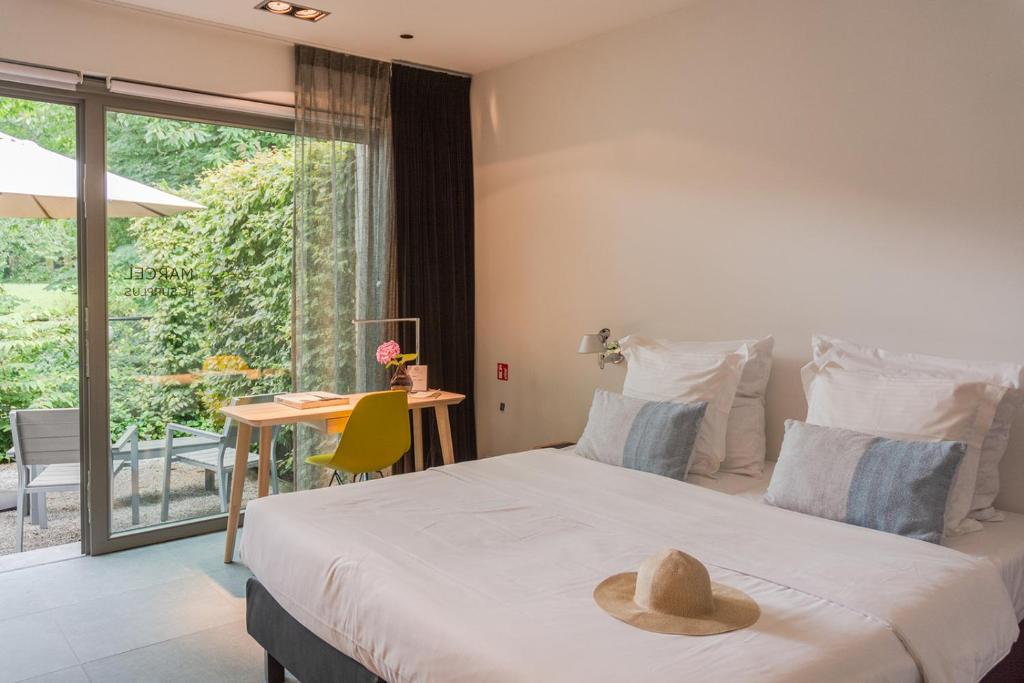 Marcel de Gand Business & Travel في خنت: غرفة نوم مع سرير مع قبعة عليه
