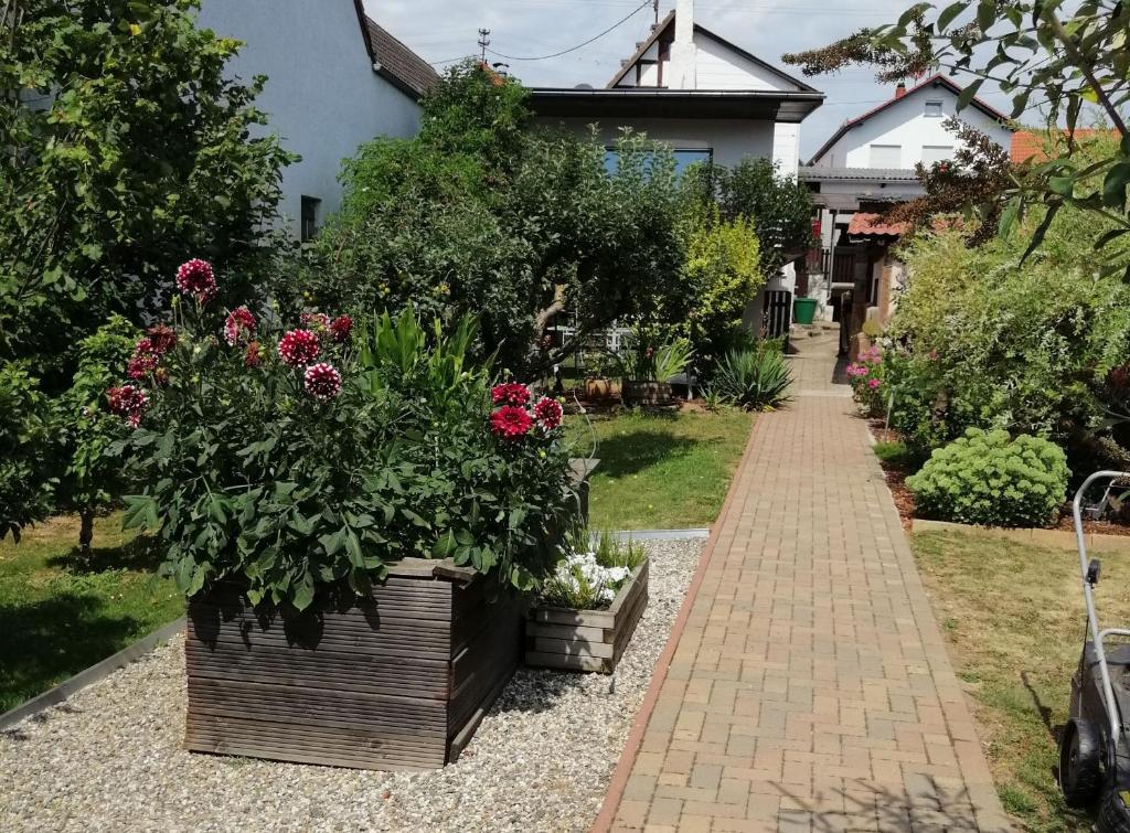 einen Garten mit Blumen und einem Ziegelsteinweg in der Unterkunft Ferienhaus Gründaublick in Gründau