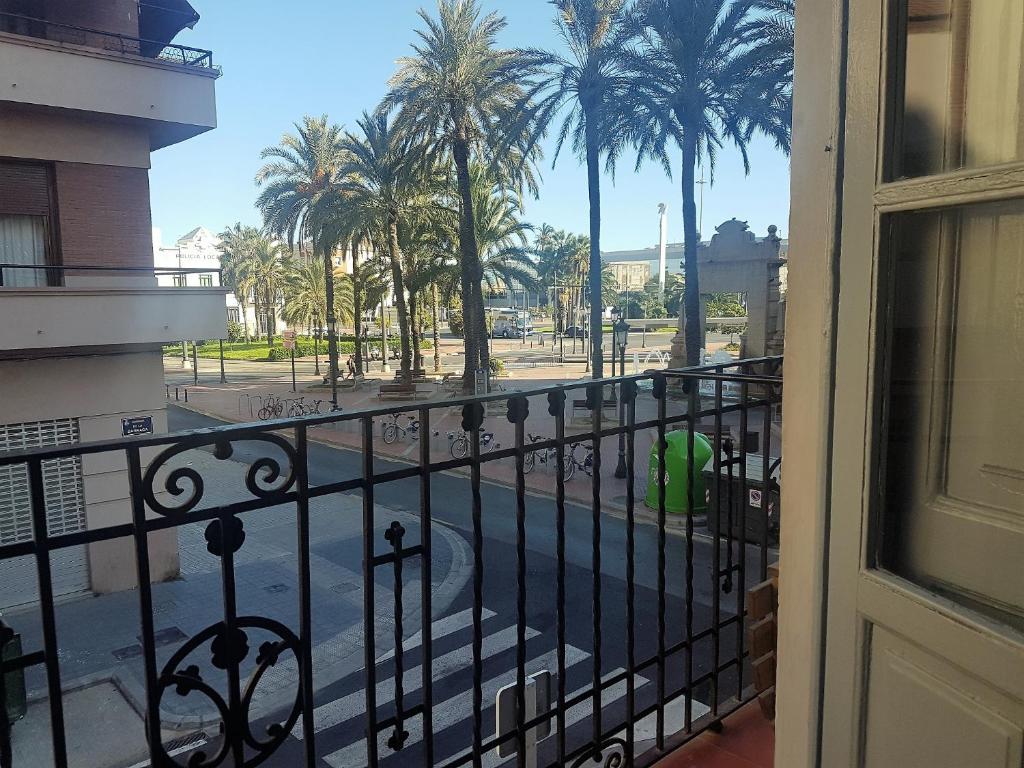 バレンシアにあるApartamento con vistas a la Marina Realの通りとヤシの木の景色を望むバルコニー