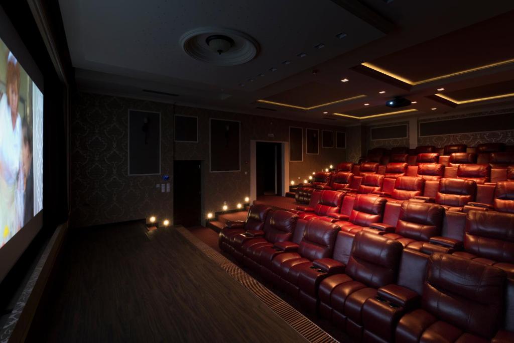 an auditorium with red chairs and a projection screen at Hotel Dvorana in Karlovy Vary