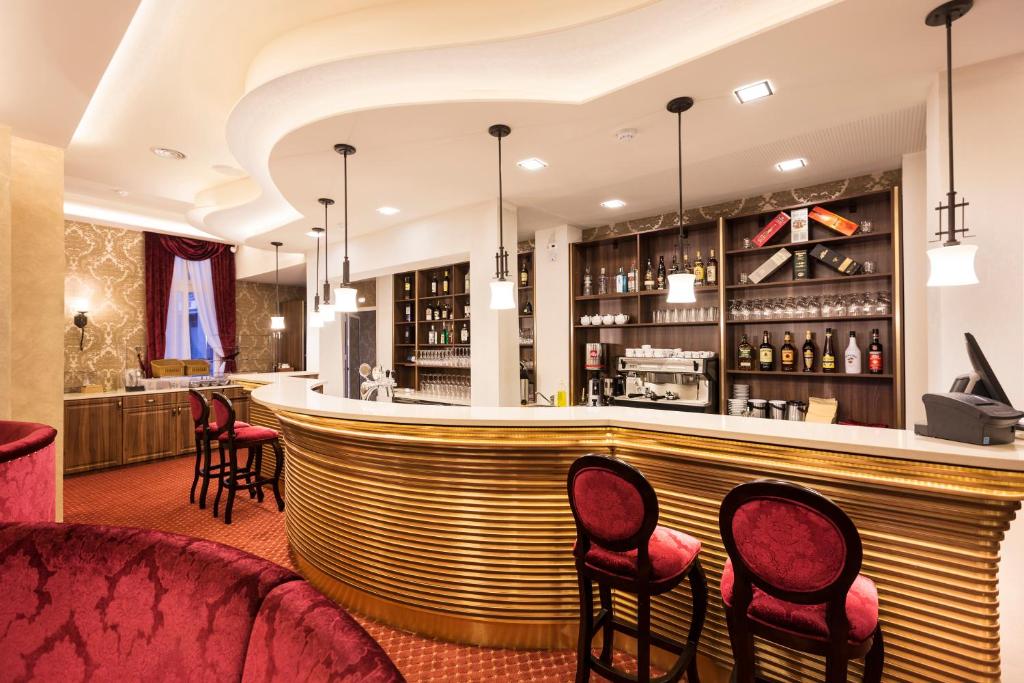 a bar at a hotel with red chairs at Hotel Dvorana in Karlovy Vary