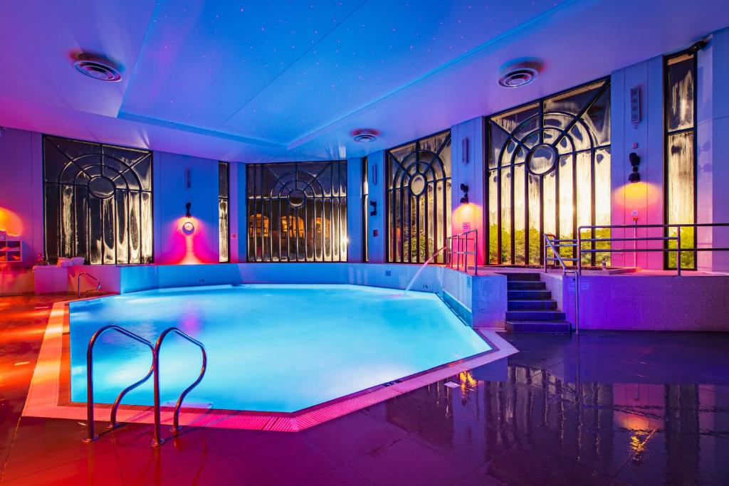a swimming pool in a room with purple lighting at Crowne Plaza Gerrards Cross by IHG in Beaconsfield