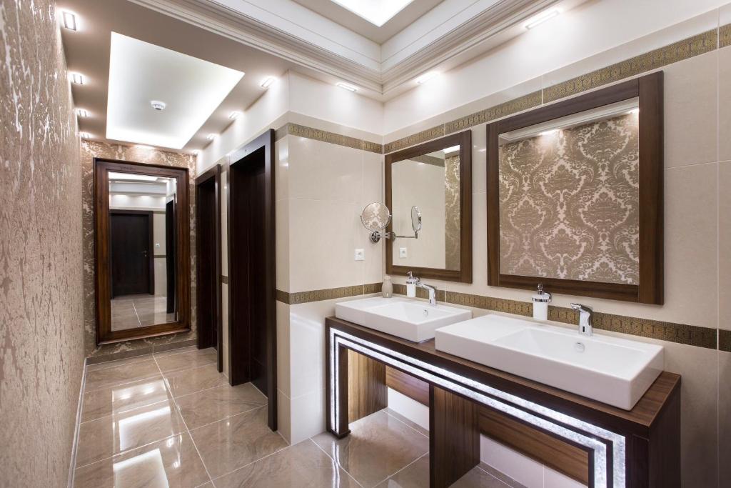a bathroom with two sinks and a large mirror at Hotel Dvorana in Karlovy Vary