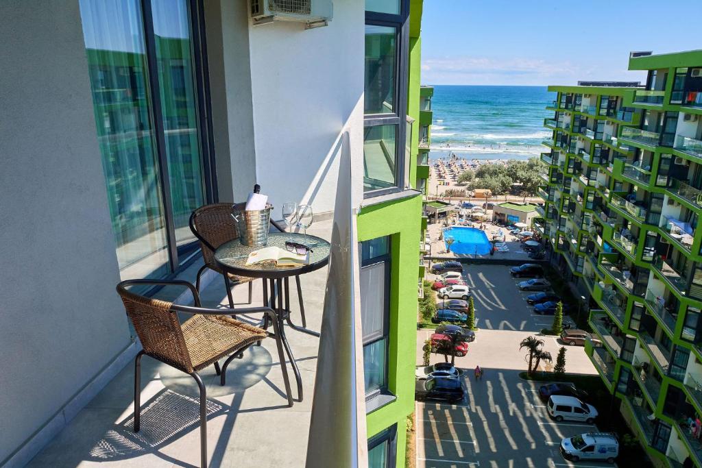 d'un balcon avec une table et une vue sur l'océan. dans l'établissement Rubic Apartment Spa n Pool beach Resort, à Mamaia Nord – Năvodari