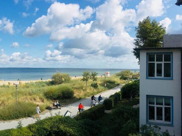 a group of people walking down a path near the beach at Kleines Strandhotel in Niendorf