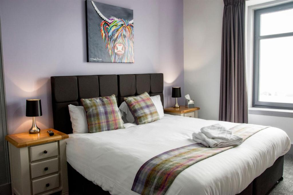The Knowes Hotel & Restaurant في Macduff: غرفة نوم بسرير ابيض كبير ومصباحين