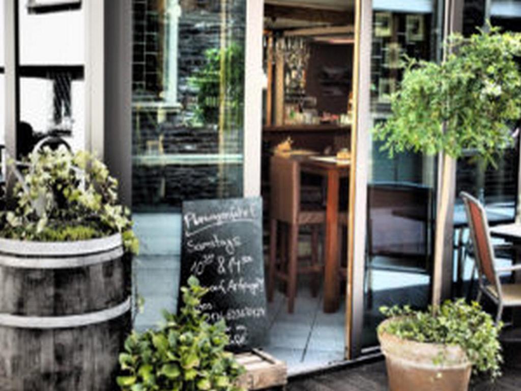 a restaurant with a chalkboard sign in front of it at Weincafé Korkenzieher in Briedel