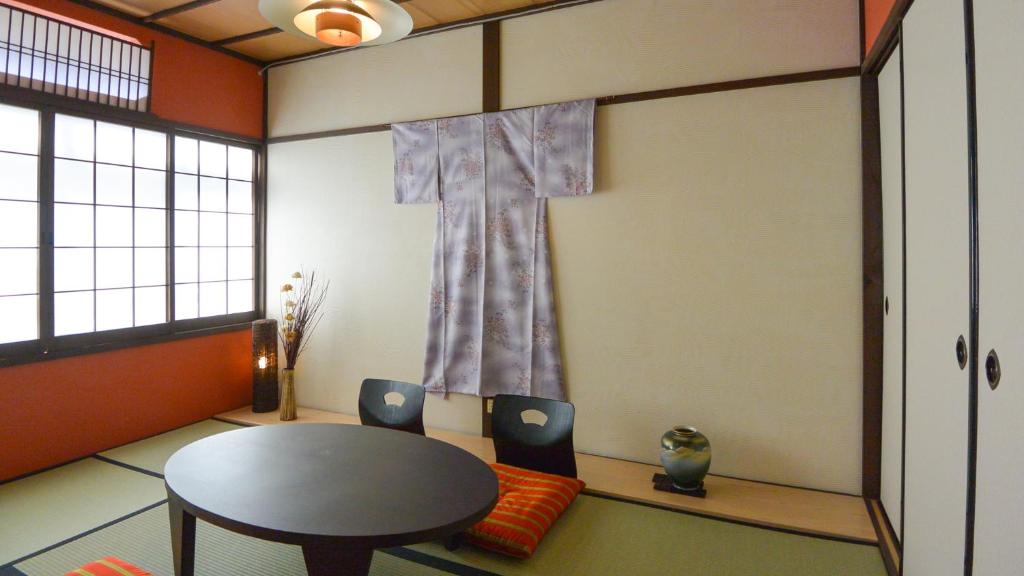 a room with a table and a cross on the wall at Kyougetsu-an in Kyoto