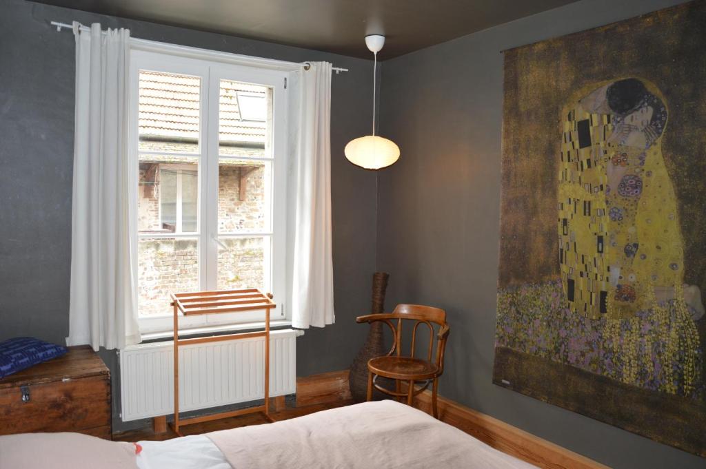 een slaapkamer met een bed, een raam en een schilderij bij L'Abricotier in Saint-Valery-sur-Somme