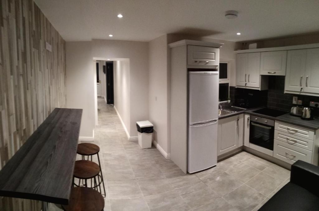 a kitchen with white appliances and a wooden table at Large Townhouse in the Heart of Galway No 12 in Galway