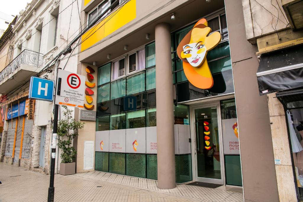 un bâtiment avec un panneau sur son côté dans l'établissement Roberta Rosa De Fontana Suites, à Rosario