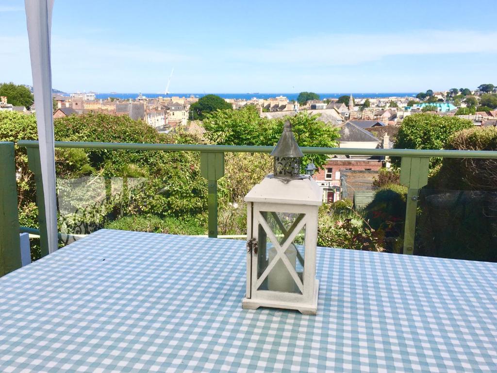 a lantern on a table with a view of a city at ORCHARD HILL HOUSE Apartment in Paignton