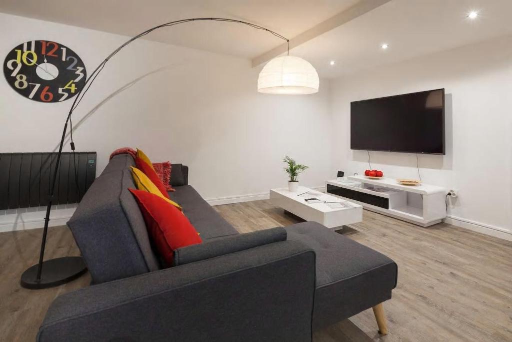 a living room with a couch and a flat screen tv at La Dimière - Appartements de standing en hyper-centre - Louviers in Louviers