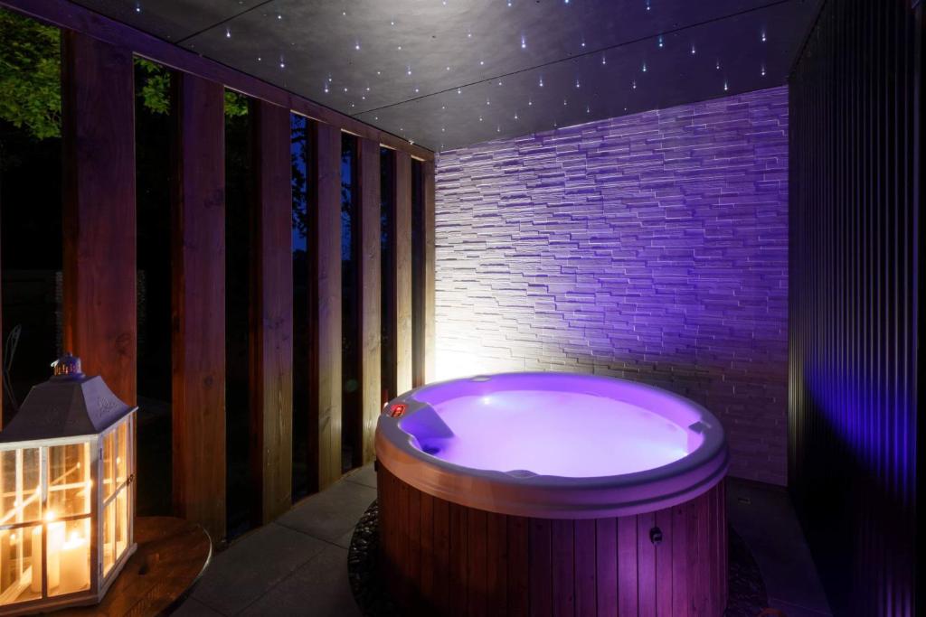 a jacuzzi tub in a room with a brick wall at La Douce Escapade in Sizun