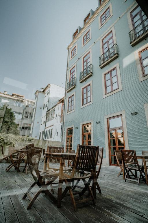 a group of chairs and a table in front of a building at Eurostars das Artes in Porto