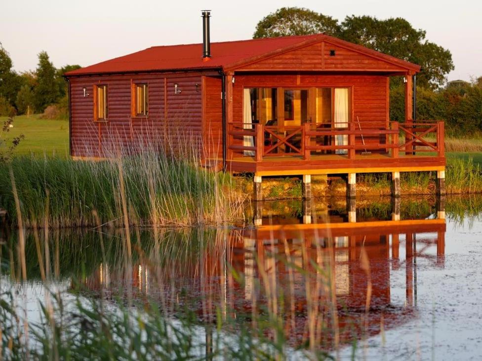 a house on a dock on a body of water at Lakeside Fishing Lodges in Boston