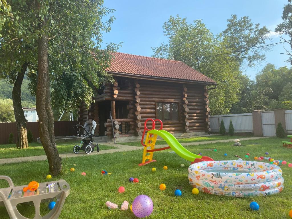 a yard filled with lots of toys and a log cabin at Villa Anna in Polyana